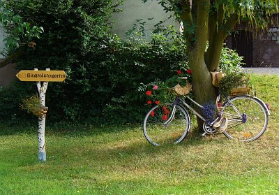 Wegweiser mit geschmücktem Fahrrad